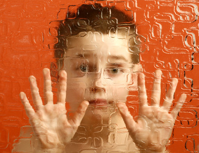 image of young boy up against a glass frame