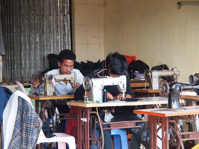image of two men using a sewing machine