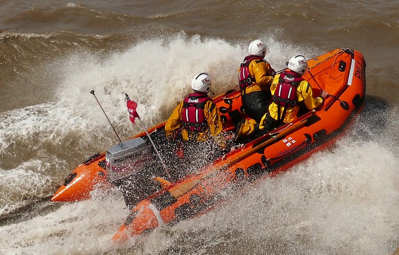Image of three men on lifeboat