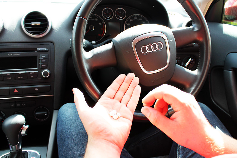 Image of man taking drugs at the wheel