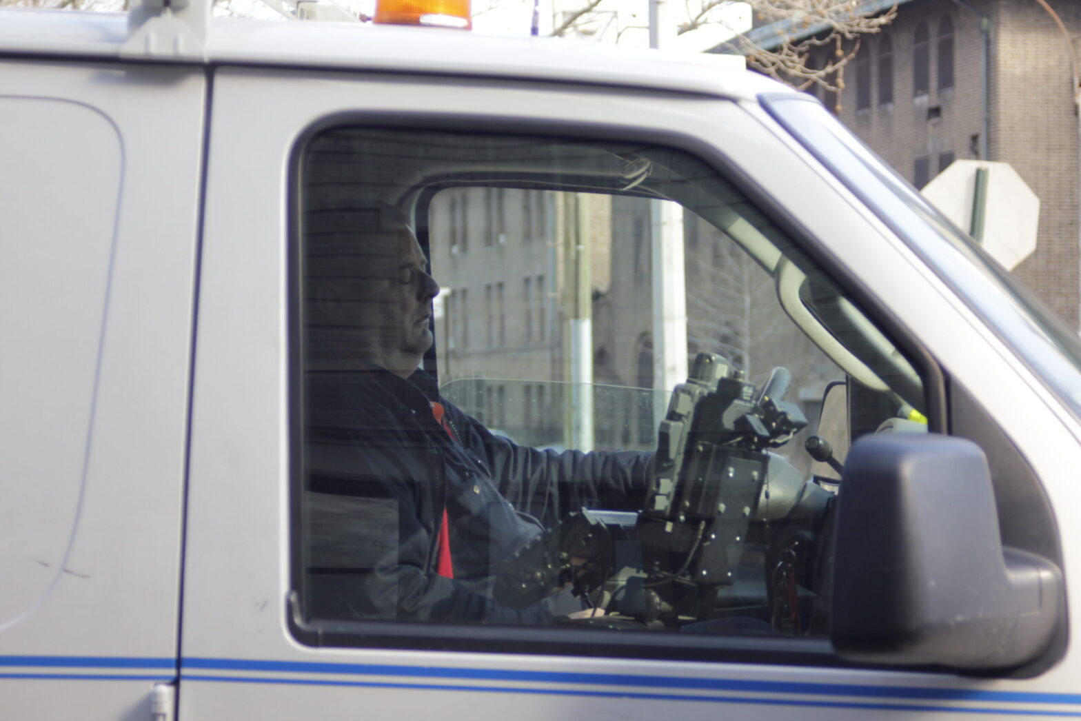 image of a man asleep behind the wheel of a van