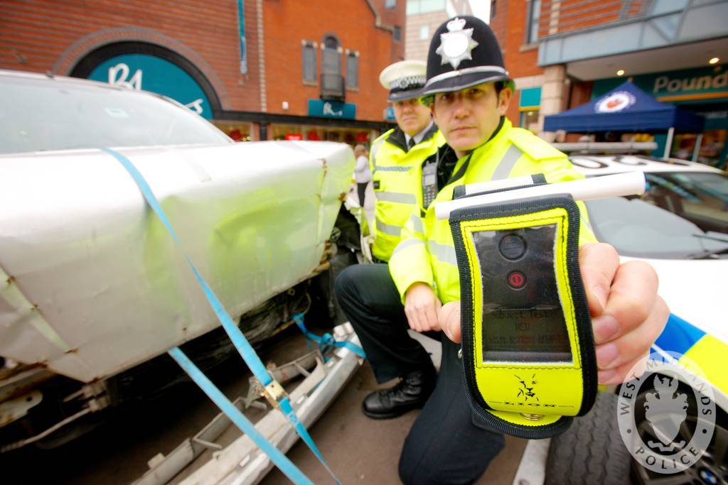image of a police officer holding a breathalyser